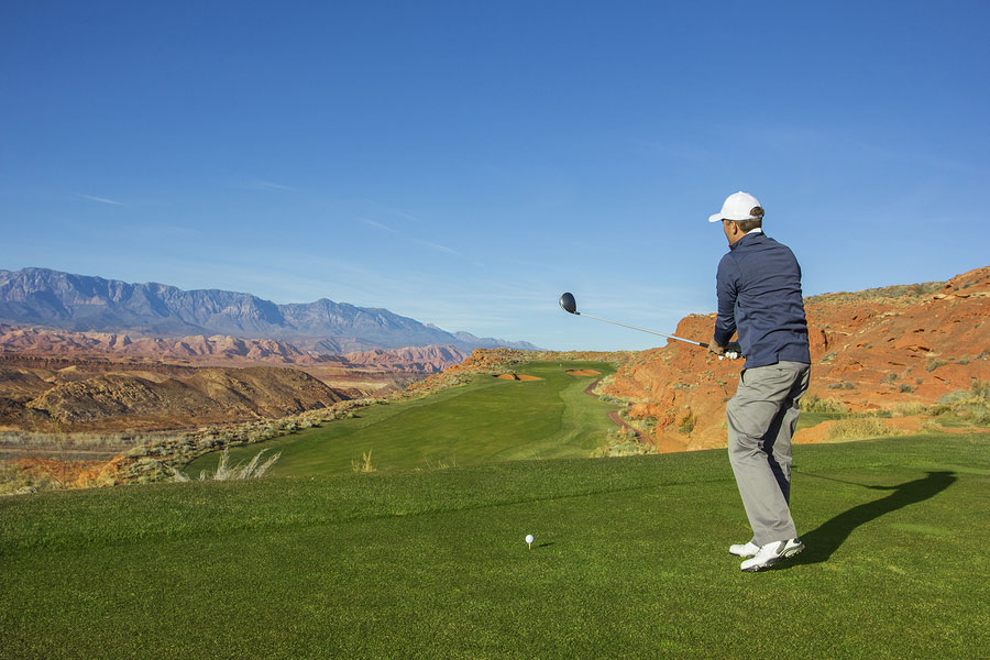 Rear view of a man playing golf on a Sunny day on a beautiful desert golf course in the Southwestern United States